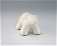 Image of baby polar bear sculpture in carrara white, portrait facing out.