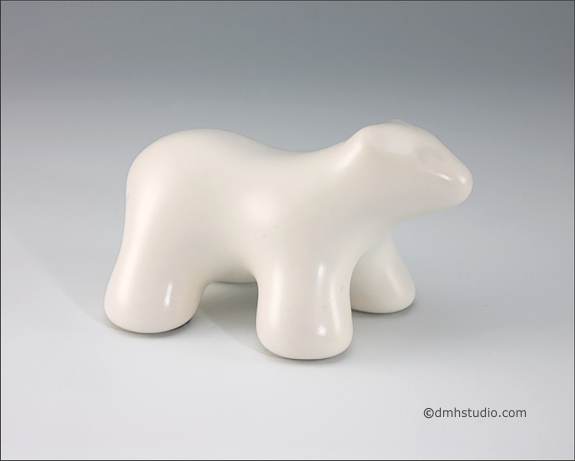 Large image of baby polar bear sculpture in carrara white, profile facing right.