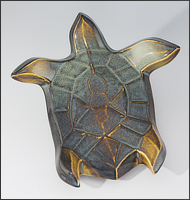 Image of Flying Sea Turtle sculpture in gold and green glaze, seen  from above, facing top of the page.