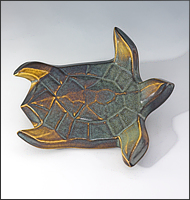 Image of Flying Sea Turtle sculpture in gold and green glaze, seen  from above, facing the viewers right.