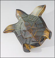 Image of Flying Sea Turtle sculpture in gold and green glaze, seen  from above, soaring to the viewers upper left.