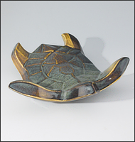 Image of Flying Sea Turtle sculpture in gold and green glaze, seen slightly from above, landing toward the viewer.