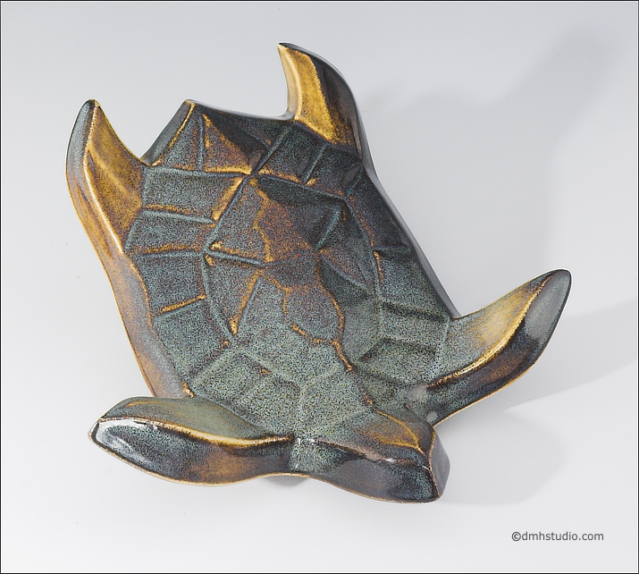 Large image of Flying Sea Turtle sculpture in gold and green glaze, seen  from above, facing down and to the viewers right.